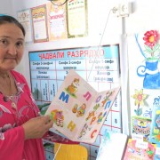 A school librarian shows off books at a library in Tajikistan established by USAID.