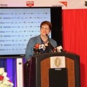 A woman stands behind a podium