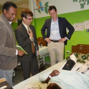 Chargé d'Affaires Peter Vrooman and hospital staff talk with a patient.