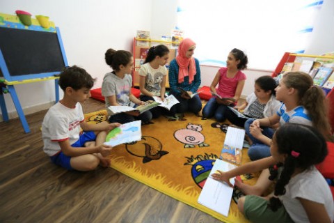 Children discuss stories they read in their weekly book club meeting with Eman Awamleh, founder of Carnaval Play & Learn.